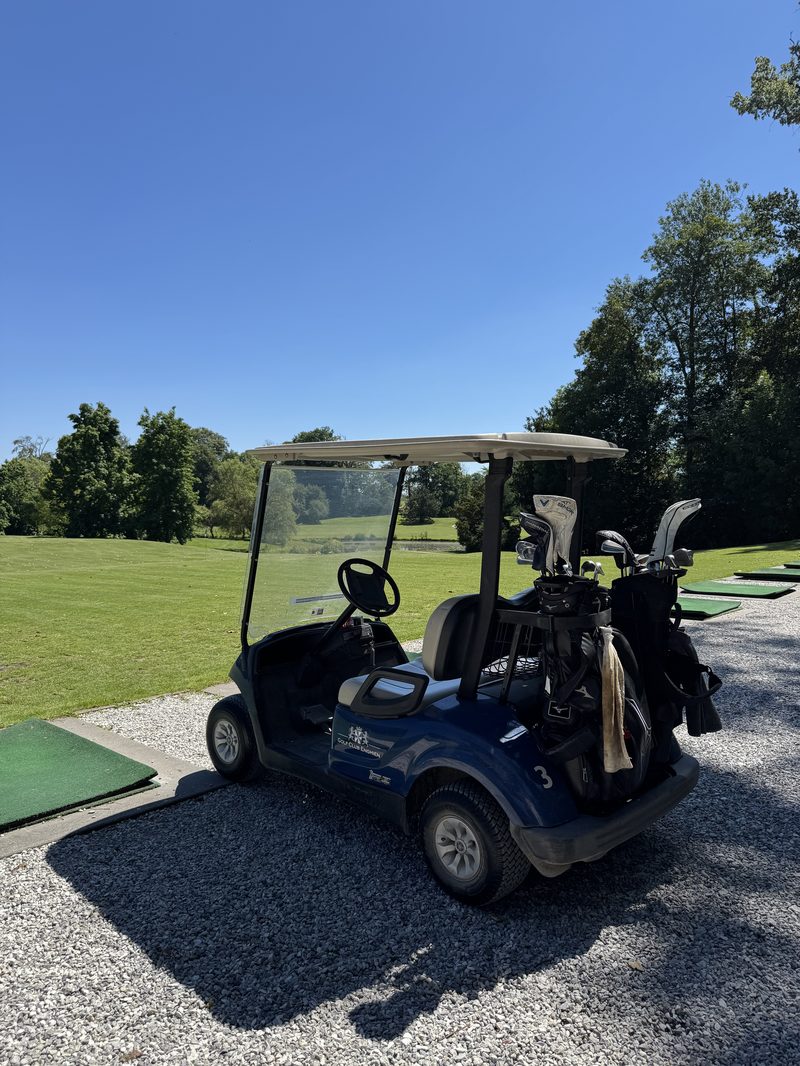 Golfcart mit Bags an der Range einer belgischen Golfanlage bei Sonnenschein